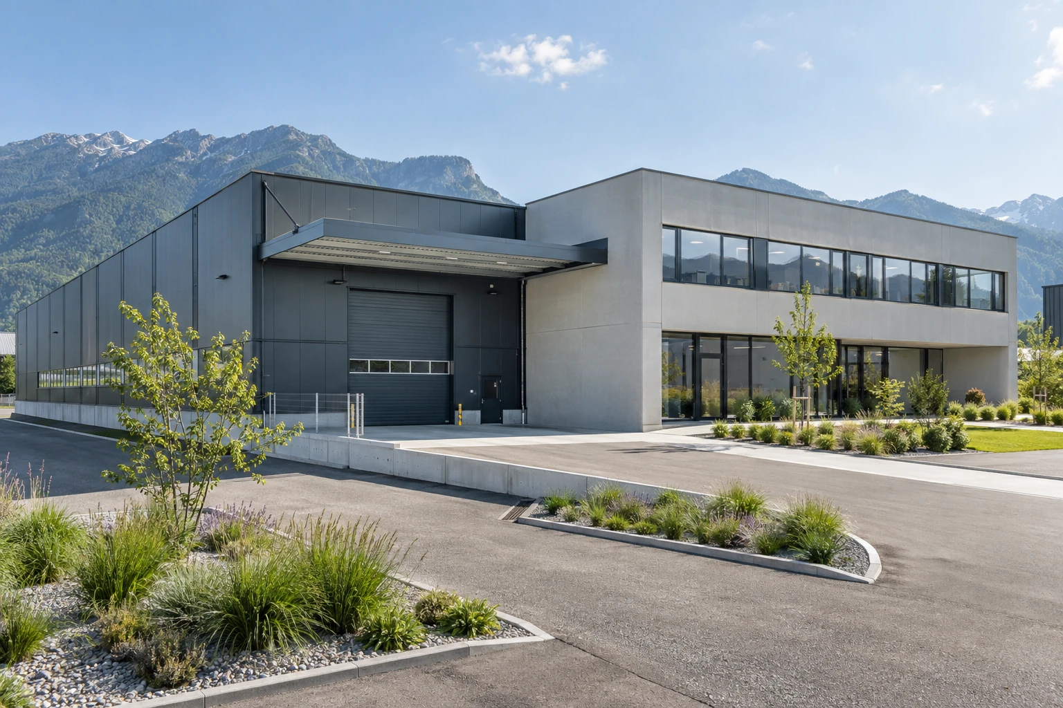Hală industrială modernă cu o clădire de birouri alăturată și dealuri în fundal